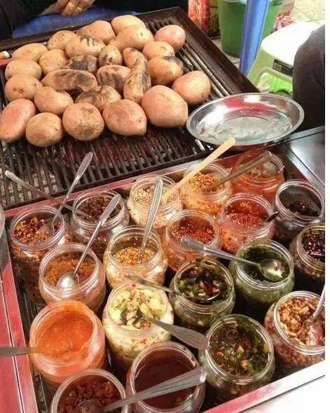 一女生从陕西来云南游玩,被满满一桌的烤洋芋蘸料惊呆了!