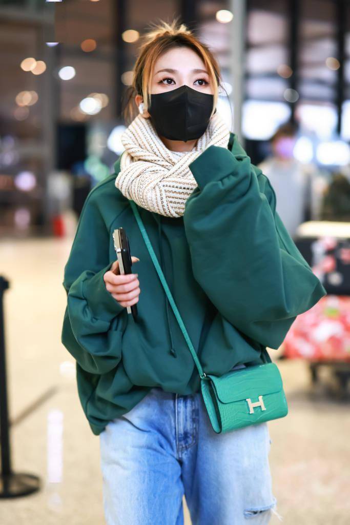 乃万身穿绿色宽版卫衣机场出行 系围巾搭破洞牛仔裤保暖又减龄_上海