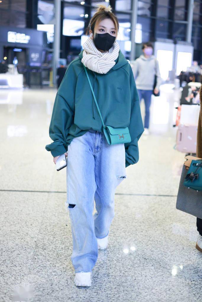 乃万身穿绿色宽版卫衣机场出行 系围巾搭破洞牛仔裤保暖又减龄_上海