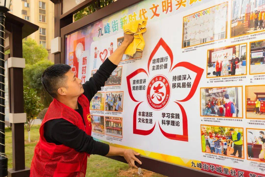 刘展鹏在擦拭小区宣传栏他们三个人还参与组建小区首届业委会,成立