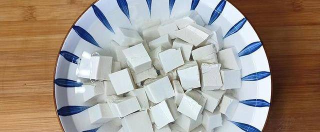 【第二步】:将豆腐皮改为和南瓜子差不多的块状,倒入一汤匙的食盐