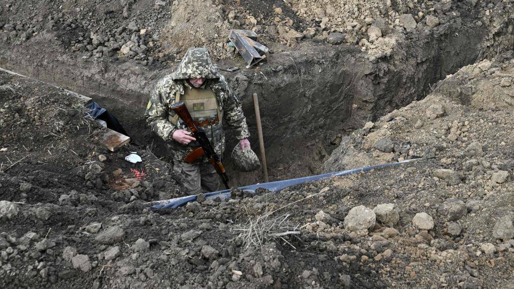 当地时间2023年2月2日,赫尔松地区,一名乌克兰士兵在阵地上走过战壕.