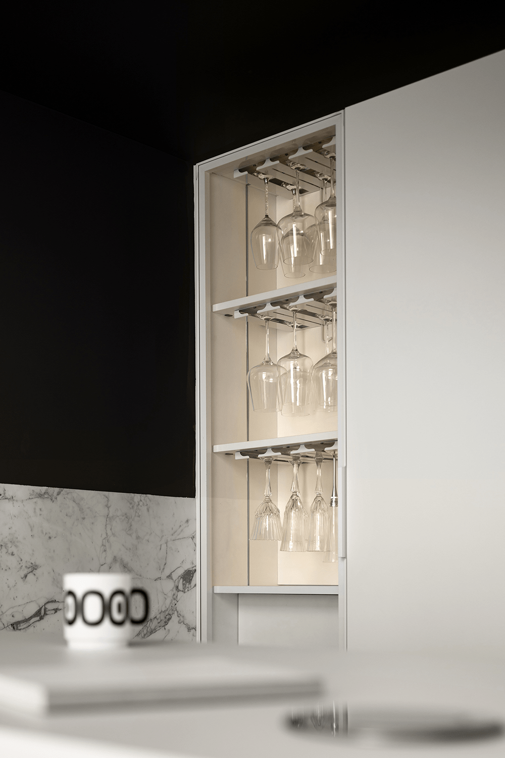 吧台背后是悬空酒柜,有开有合的柜体满足不同的收纳需求,黑色墙漆与