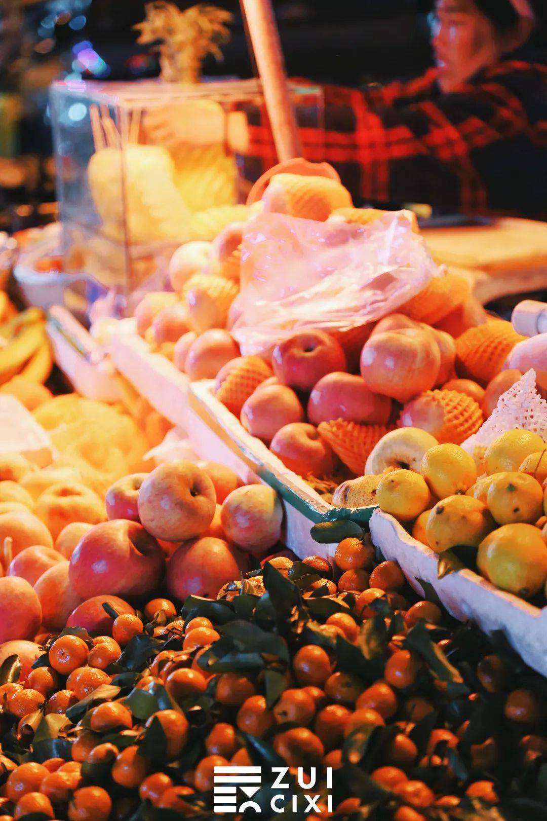 水果摊也是这里的主力军,偏红色的灯光下堆成的"橘子山","苹果山"