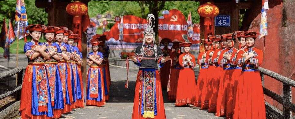 身穿畲族"凤凰装"的年轻女性在村庄入口处向来往游客行"手势礼",对