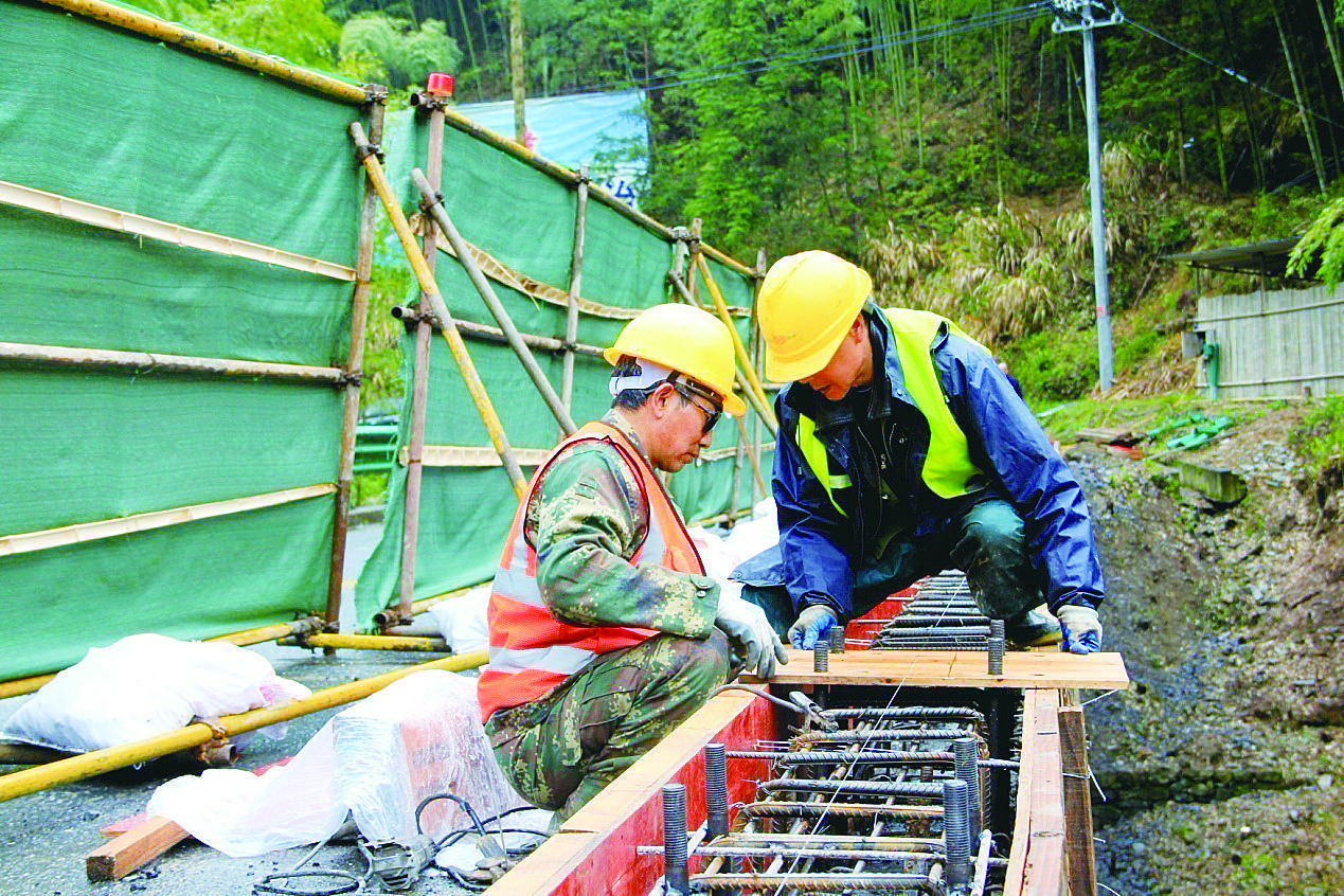 近日,在s222省道休寧友誼橋加固維修現場,施工人員利用降雨間歇,對