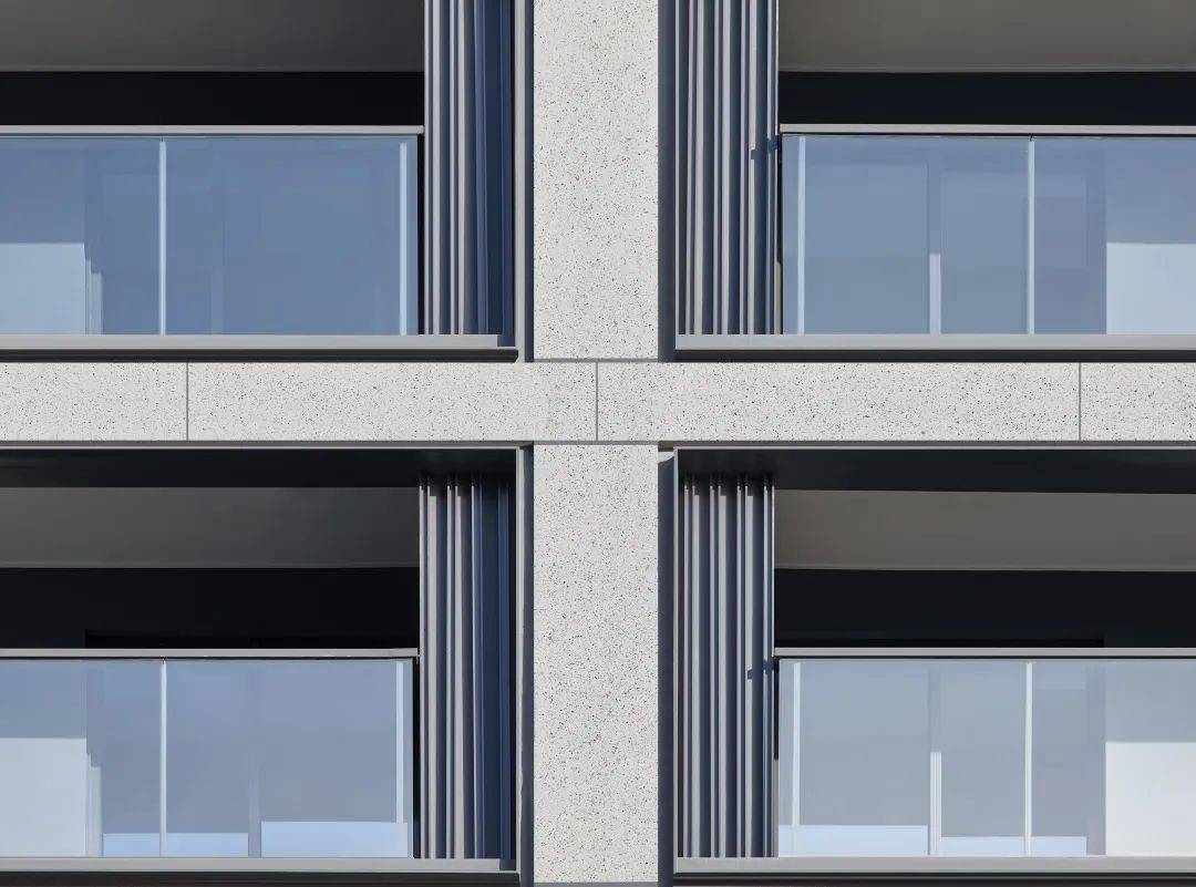 我们通过调整仿石涂料的分缝比例和缝宽变化(30mm和10mm的宽窄缝变化)