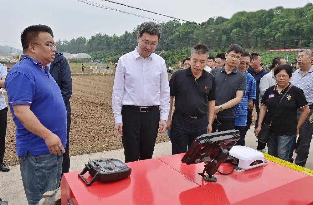 参会人员在石沱镇光明村现场观摩丘陵山地智能农机作业演示当天下午