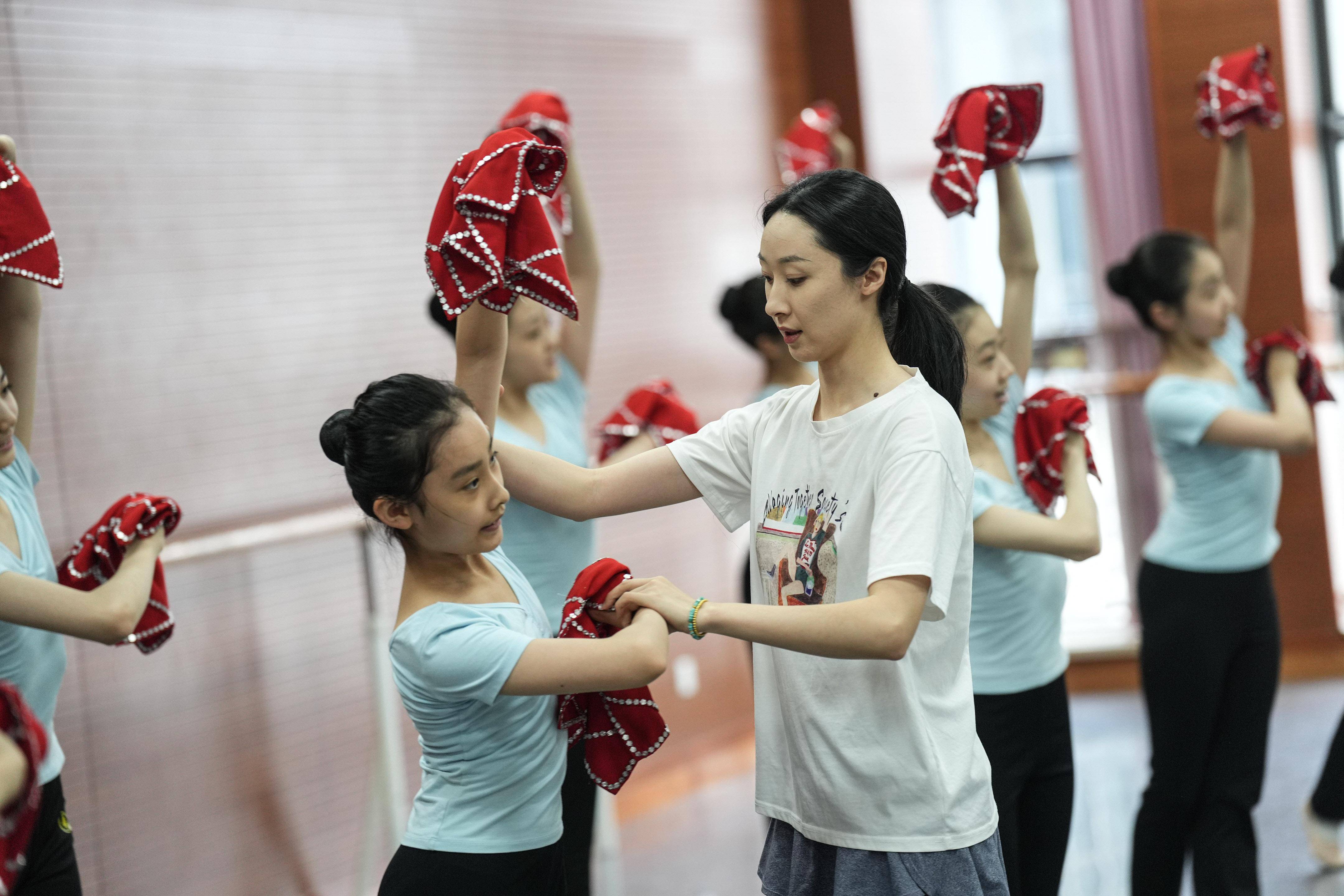 5月30日,辽宁芭蕾舞团附属芭蕾舞蹈学校的老师在为二年级的学生纠正