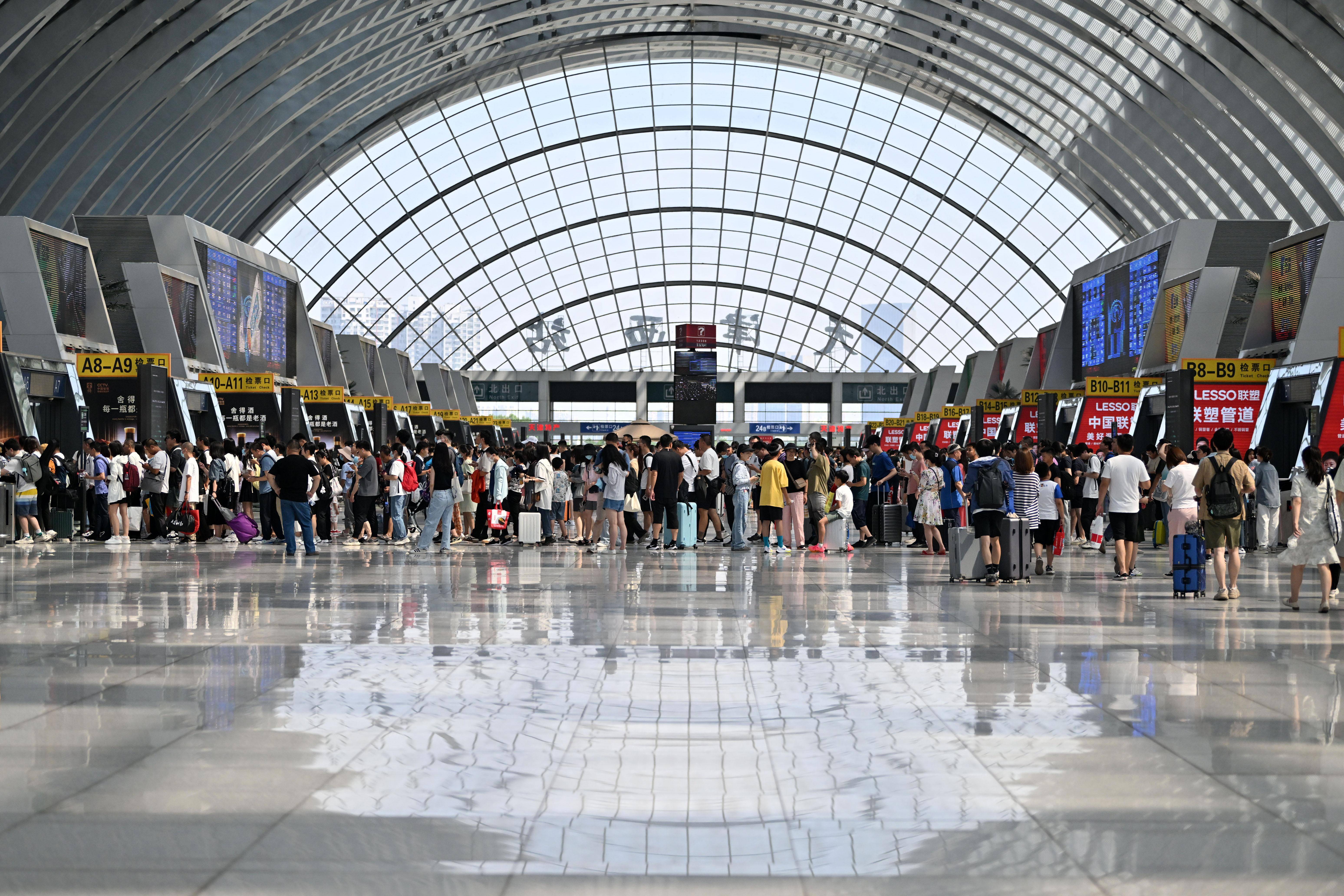 7月1日,旅客在天津西站候车大厅排队检票