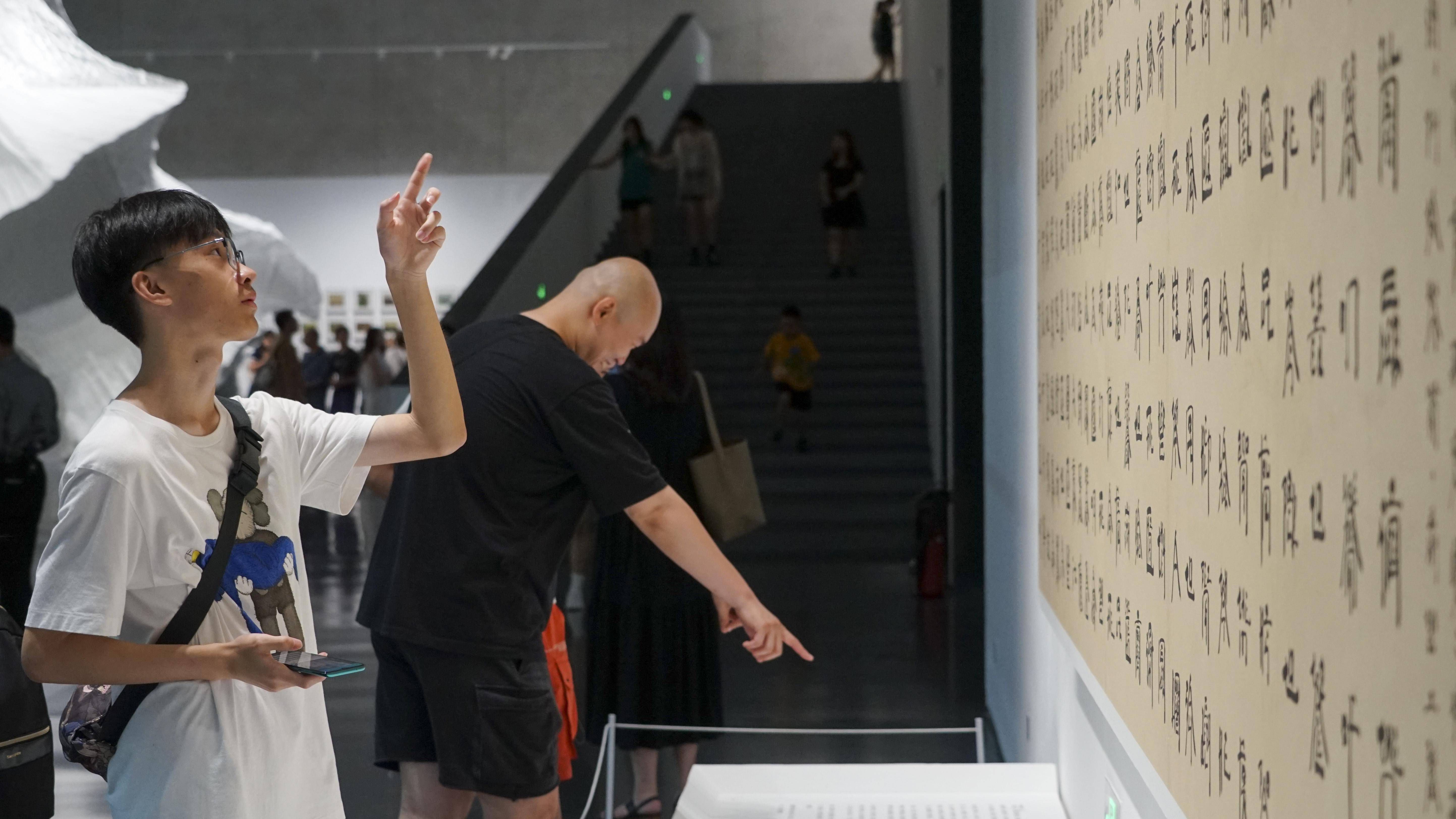 8月4日,在"2023成都双年展"艺术家徐冰的"英文方块字书法教室"内,参与