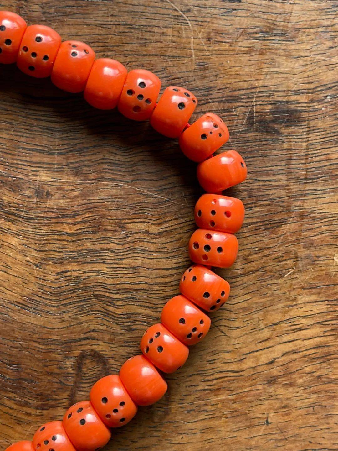 这是一组108粒仿红珊瑚老骰子纹雪巴珠串成的长项链,这组佛珠的特色是