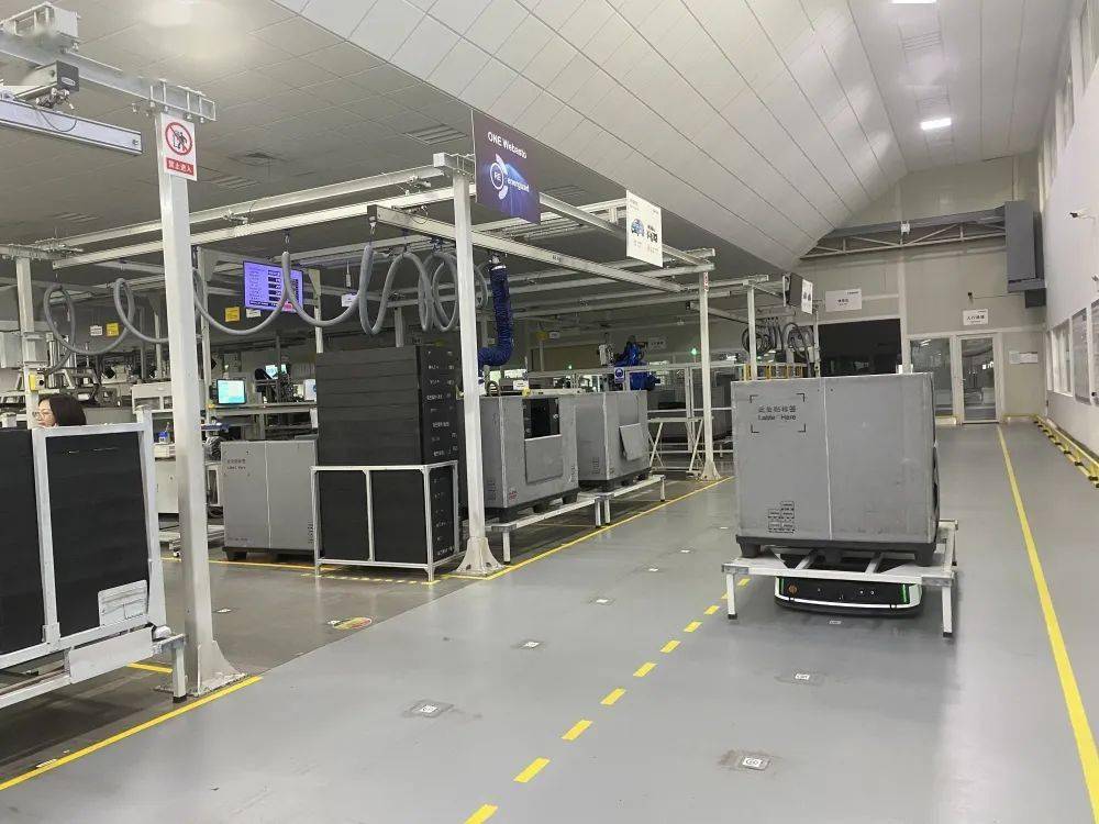 伟巴斯特重庆工厂车间内,agv智能搬运小车正在搬运刚下线的产品.