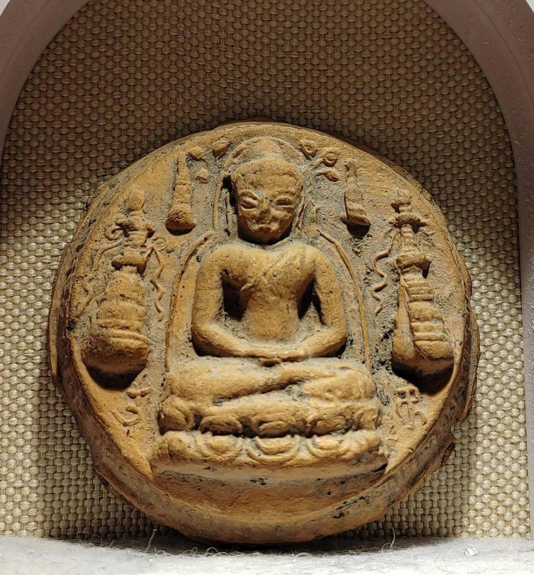 身着袈裟,袒右肩,扣纽结于左肩,结跏跌坐于双层莲台座上,右掌叠置足上