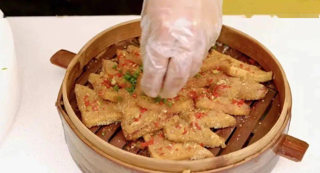 东方会馆的石宝蒸豆腐,采用先炸,后炒料汁浸泡,裹上米面反复淋酱汁蒸