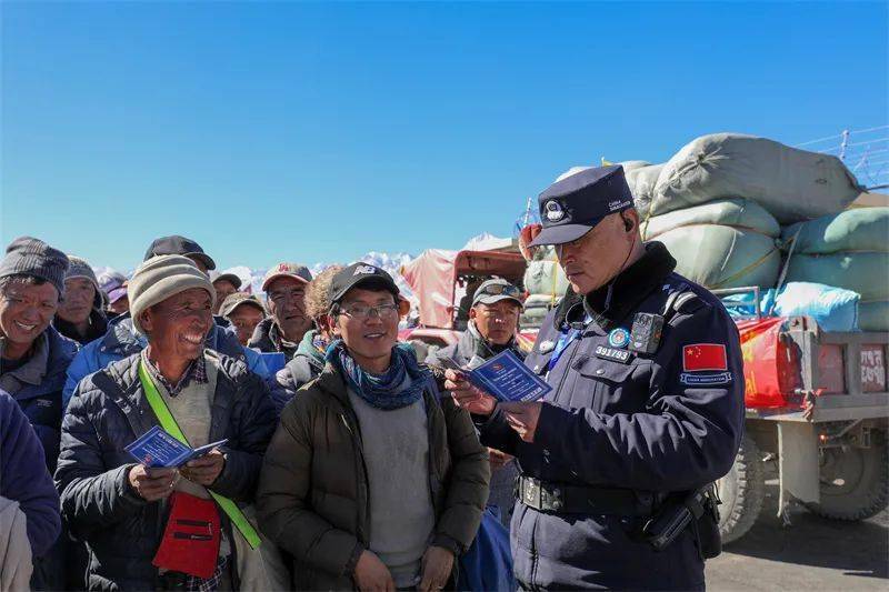 西藏邊檢總站裡孜邊檢站移民管理警察查驗首批通關旅客證件.